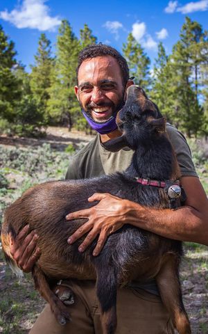 a wwoofer holding a goat